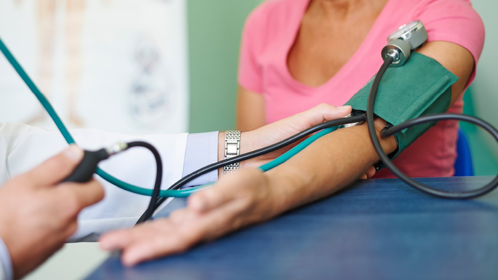 Profesional de la salud midiendo la presión arterial de una paciente mayor con un tensiómetro manual durante un chequeo preventivo.